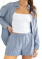 Woman wearing a blue and white striped shirt and shorts set on a white background