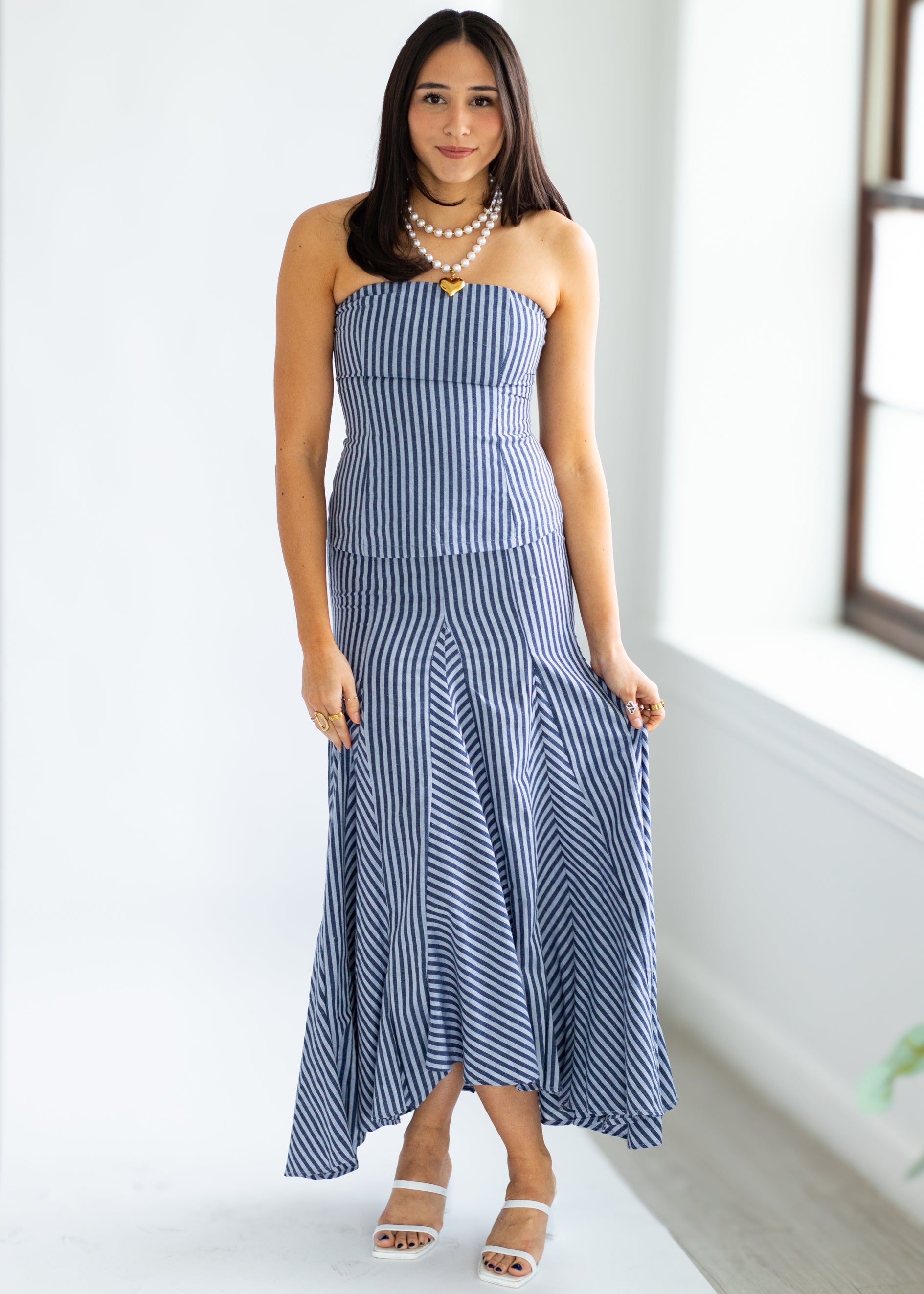 Woman wearing a blue and white striped dress in a bright room.