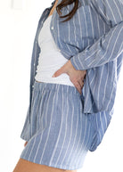 Person wearing a blue and white striped shirt and shorts on a white background