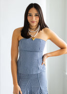 Woman wearing a blue and white striped dress with a plain background