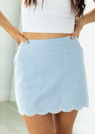 Light blue skirt with scalloped hem worn by a person on a white background