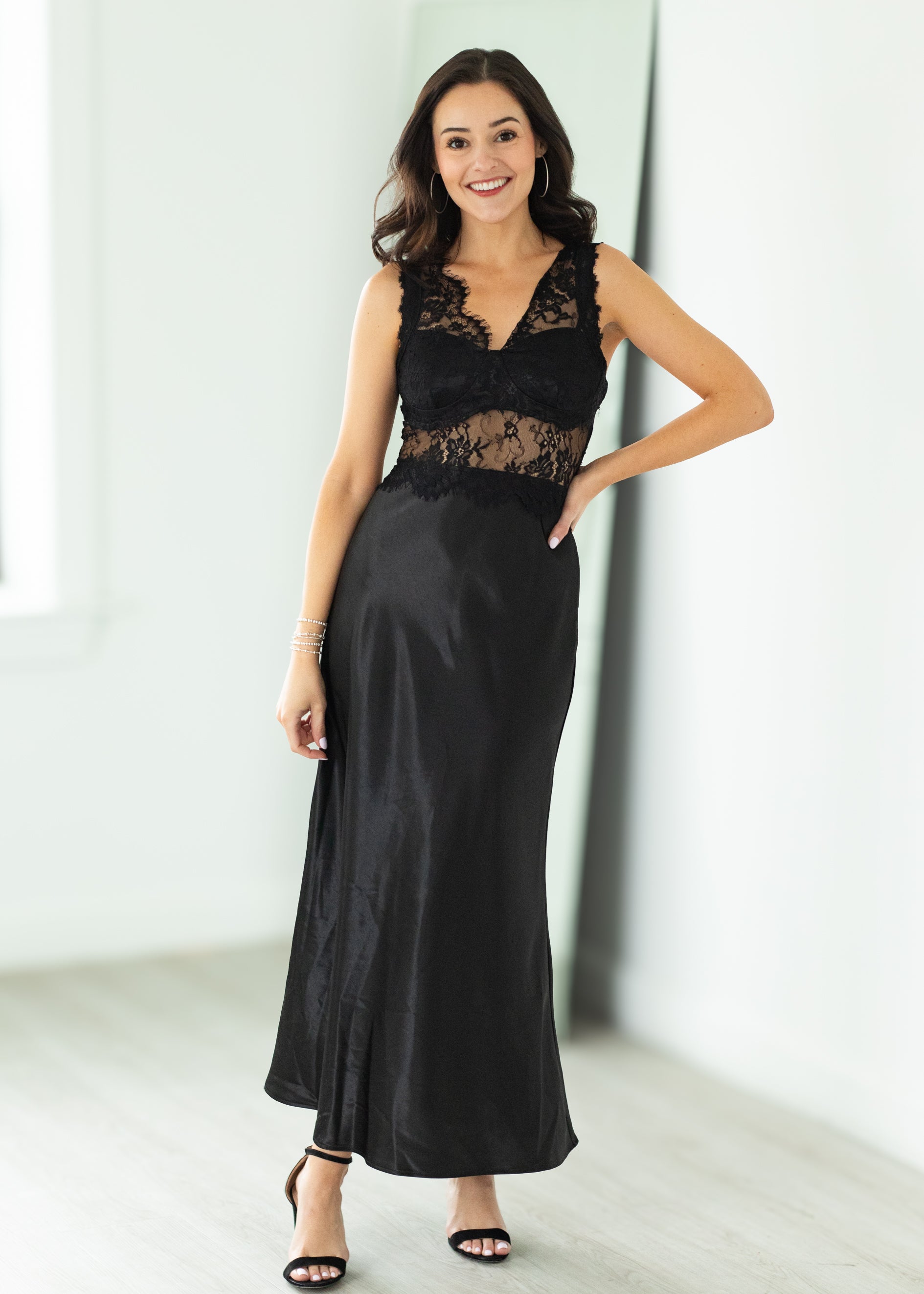 Woman wearing a black lace dress against a white background