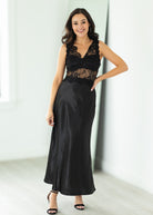 Woman wearing a black lace dress against a white background