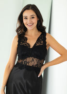 Woman wearing a black lace dress against a white background
