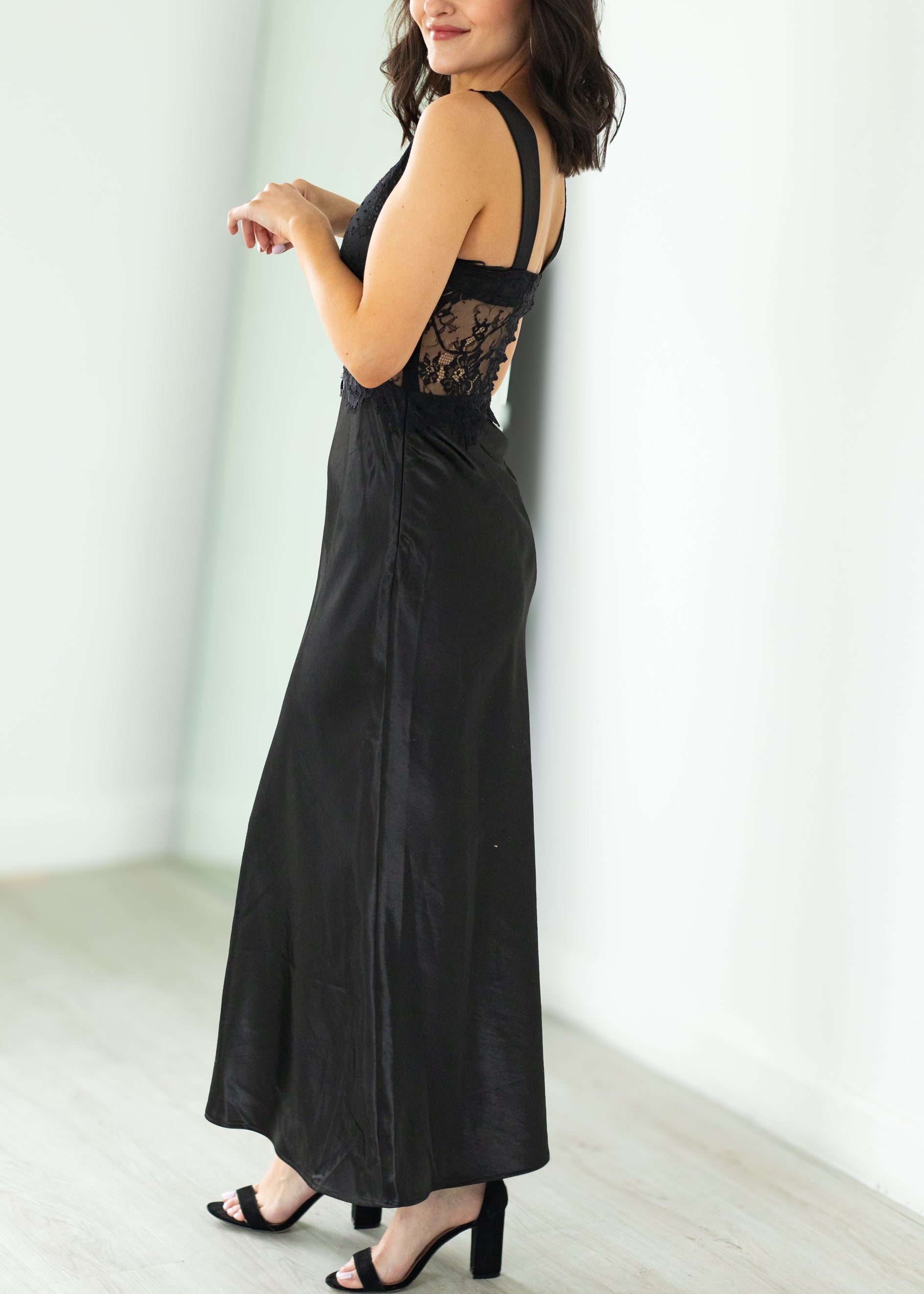 Woman wearing a black lace dress against a white background