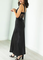 Woman wearing a black lace dress against a white background