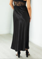 Woman wearing a black lace dress against a white background