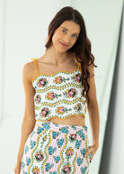 Woman wearing a floral two-piece outfit against a white background