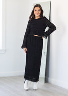 Woman wearing a black outfit set standing in front of a mirror.