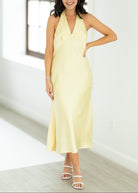 Woman wearing a light yellow dress in a bright room