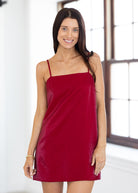 Woman wearing a red slip dress indoors