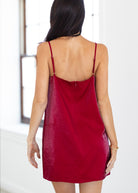 Red slip dress worn by a person with a white background