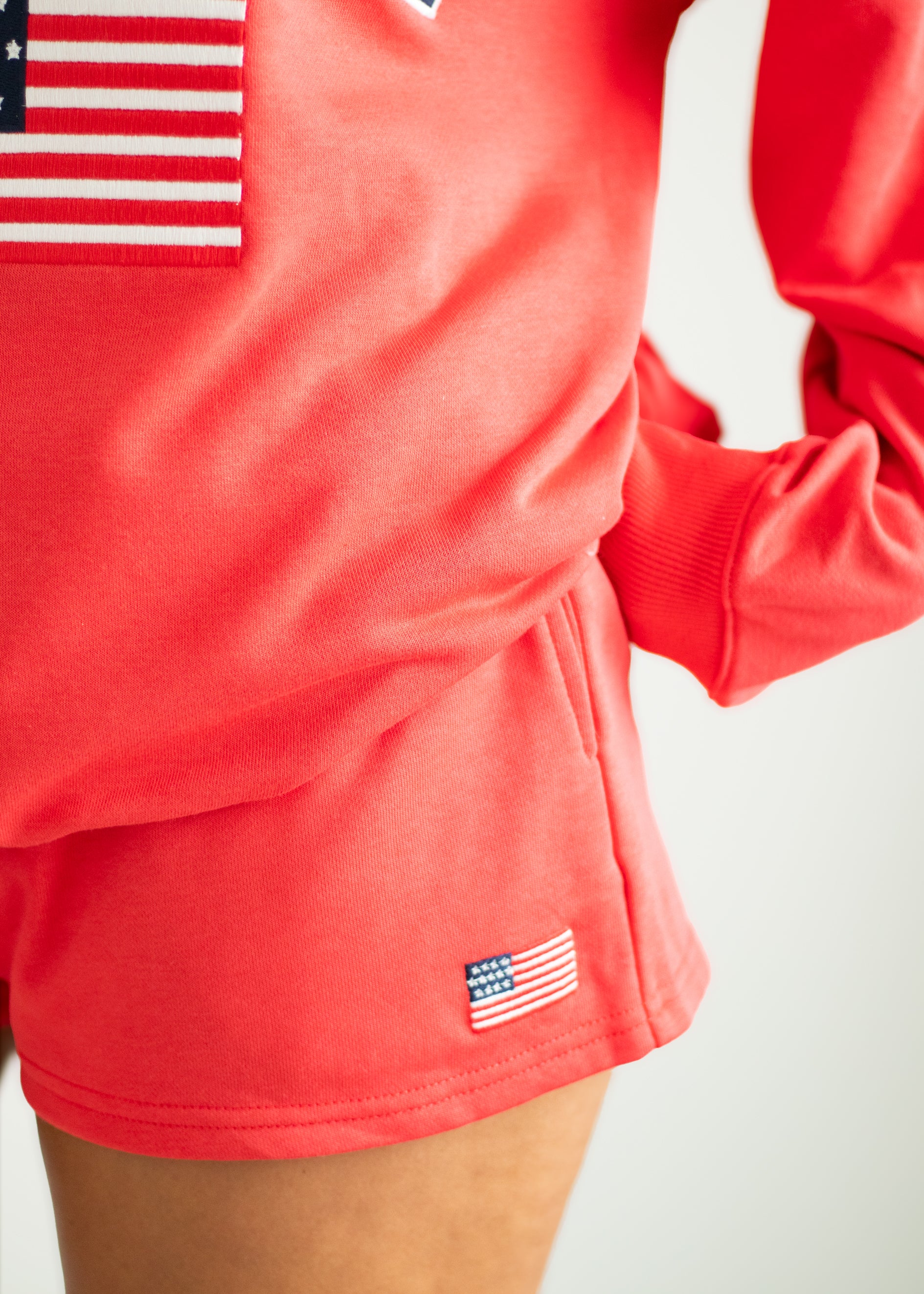 Red athletic outfit with American flag details on a plain background
