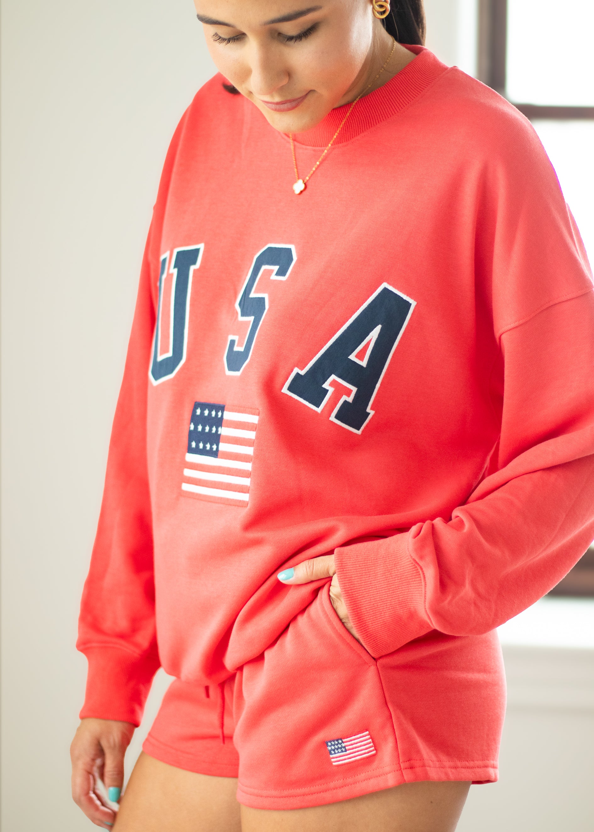 Person wearing a red 'USA' sweatshirt with an American flag design.