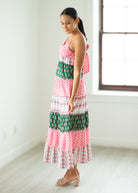 Woman wearing a colorful patterned dress in a bright room.