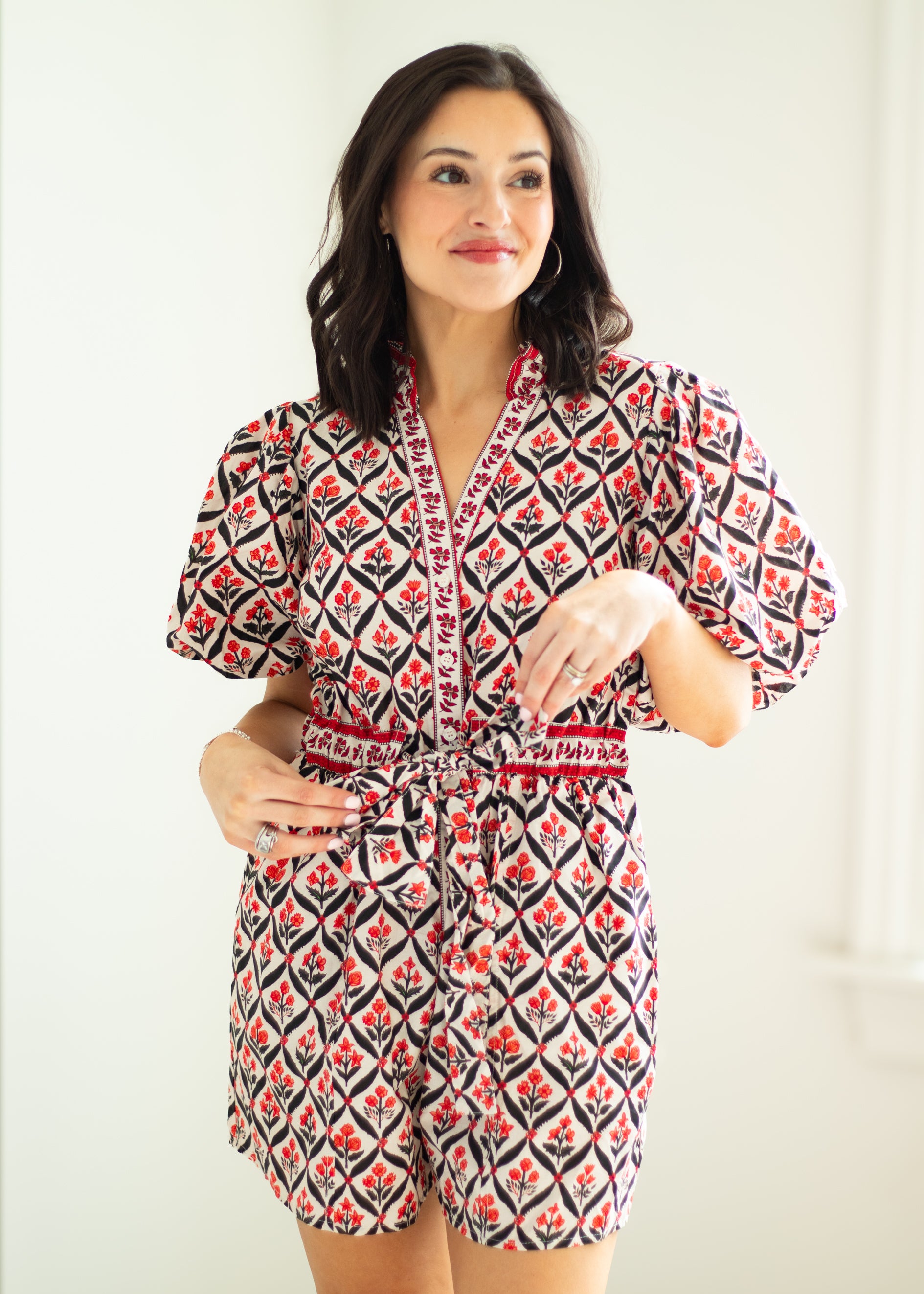 Woman wearing a patterned romper against a plain background