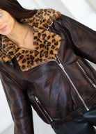 Brown leather jacket with leopard print collar on a white background