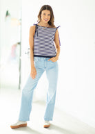 Woman wearing a striped top and light blue jeans on a white background