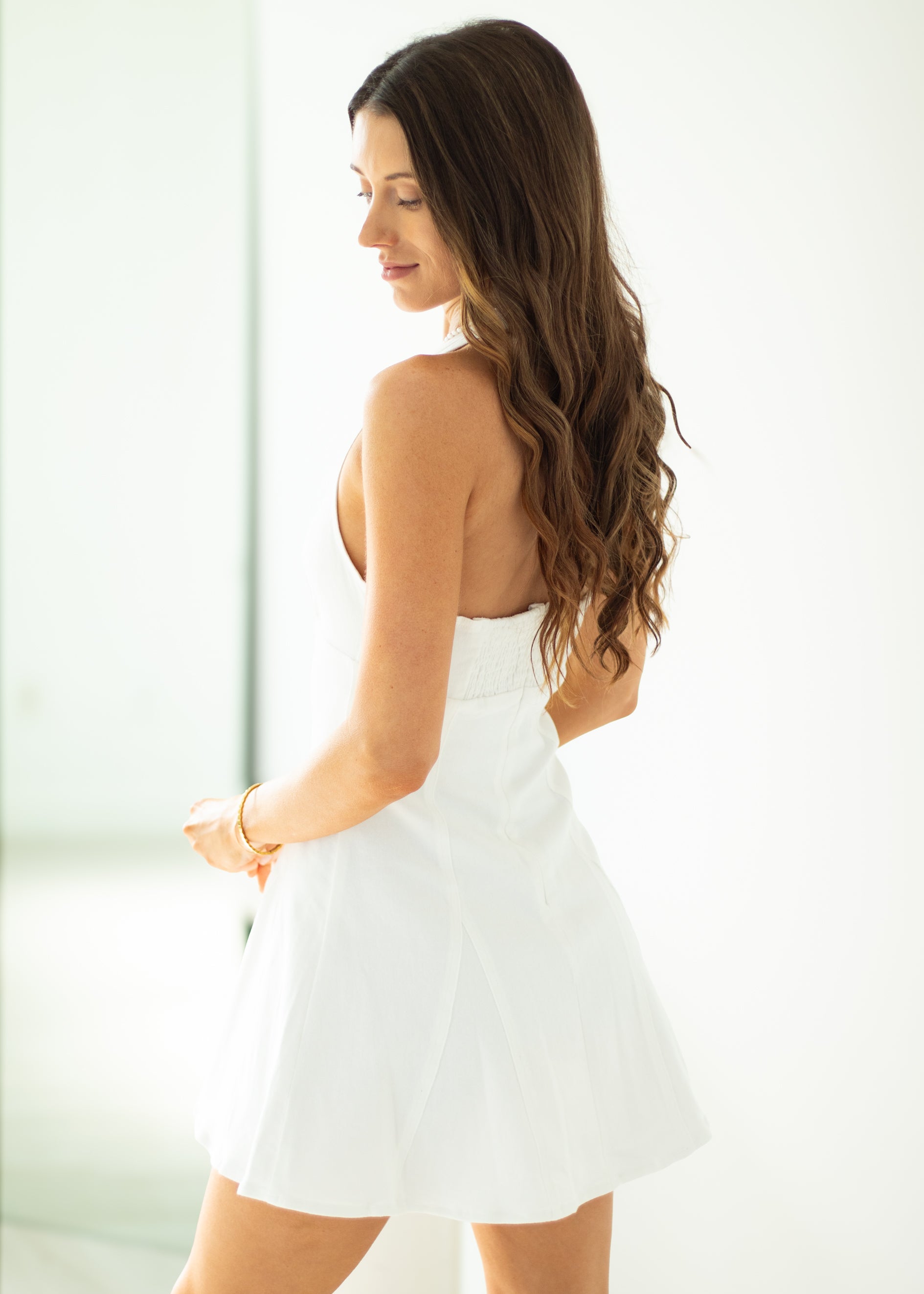Woman wearing a white dress against a light background