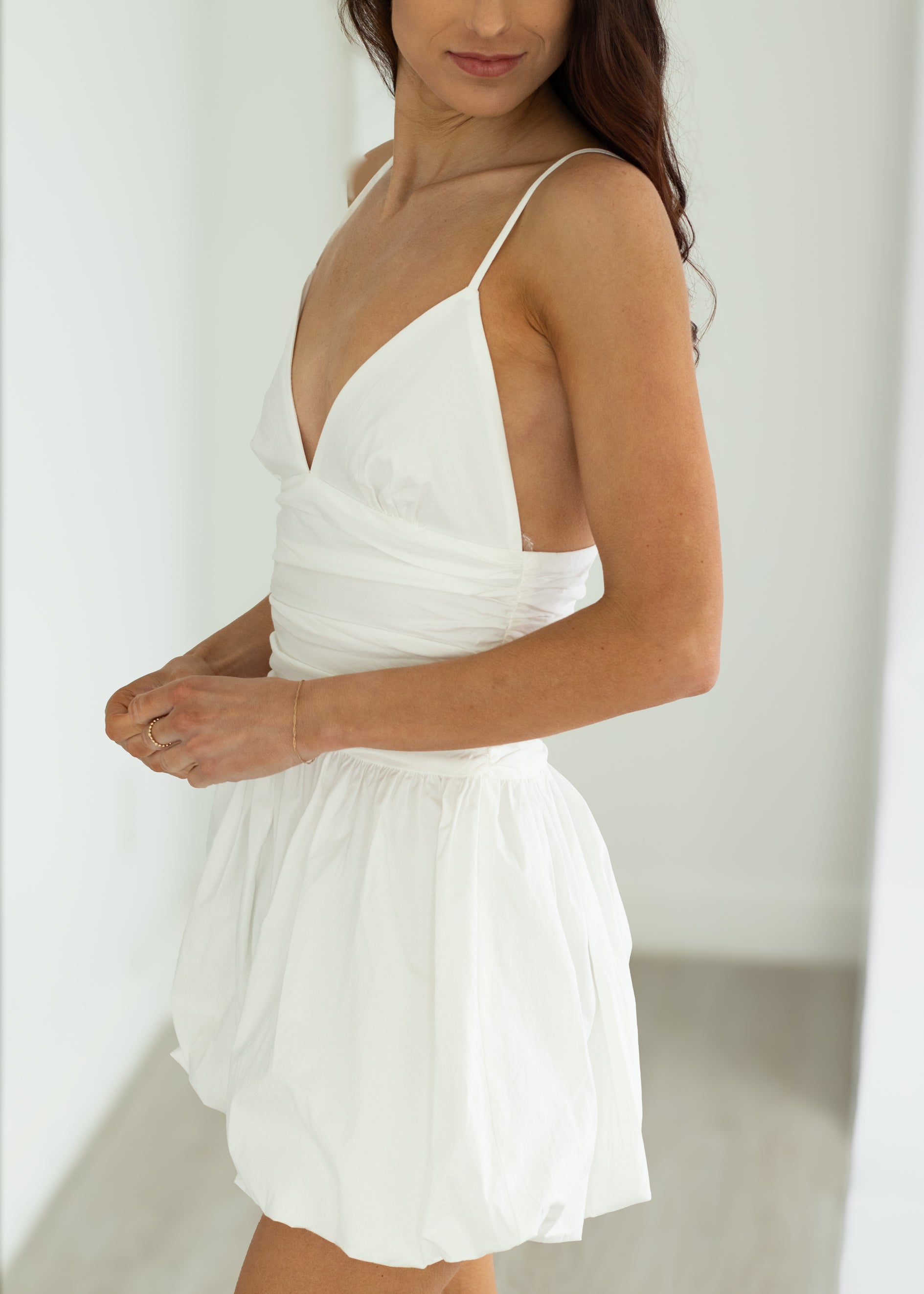 Woman wearing a white dress against a plain background