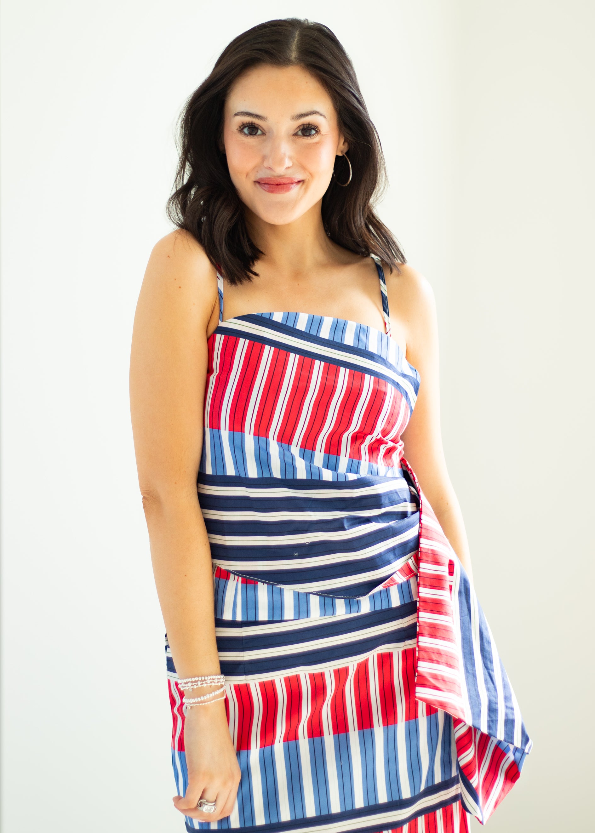 Woman wearing a red, white, and blue striped dress on a white background