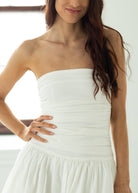 Woman wearing a strapless white dress with a blurred background