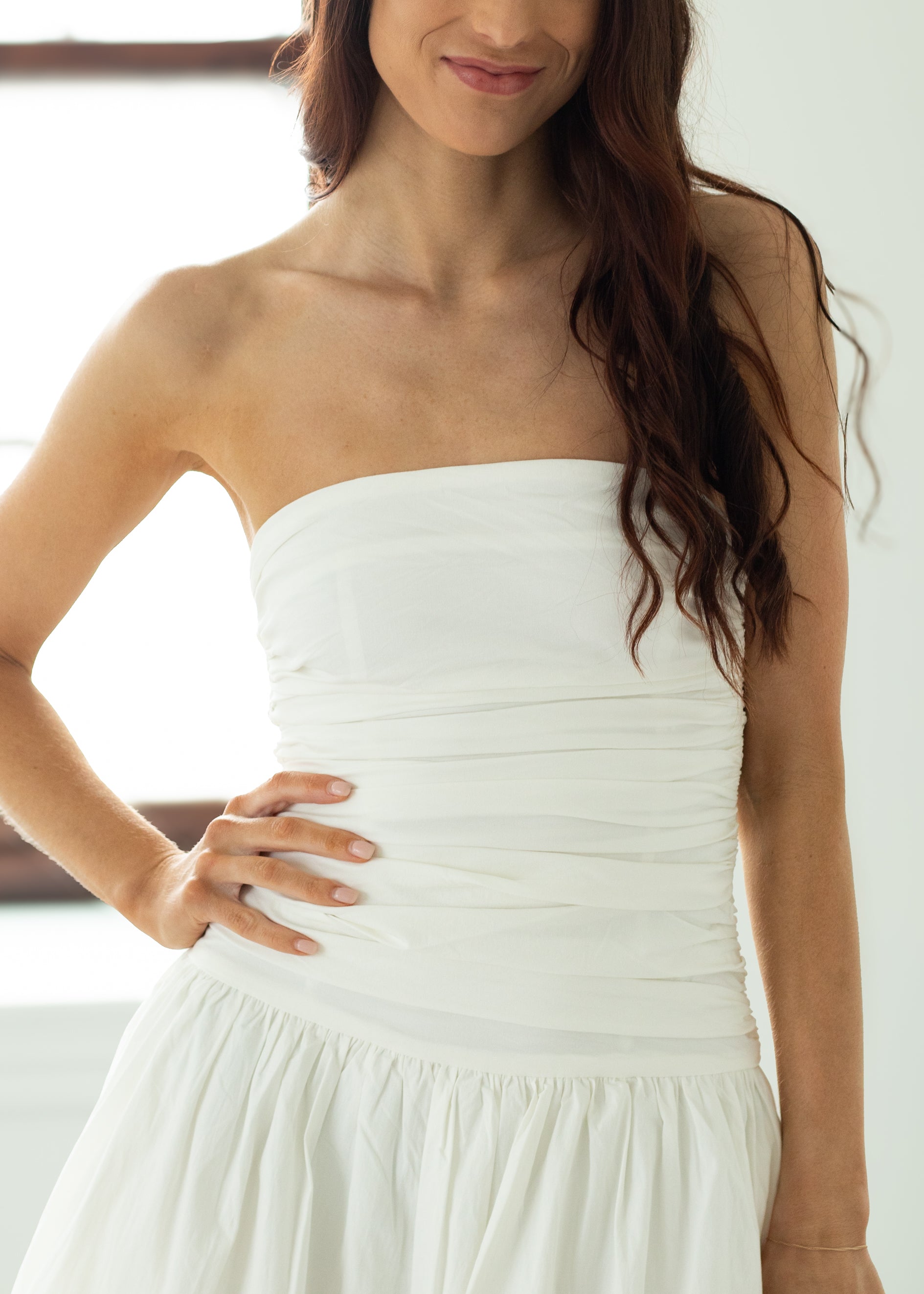 Woman wearing a strapless white dress with a blurred background