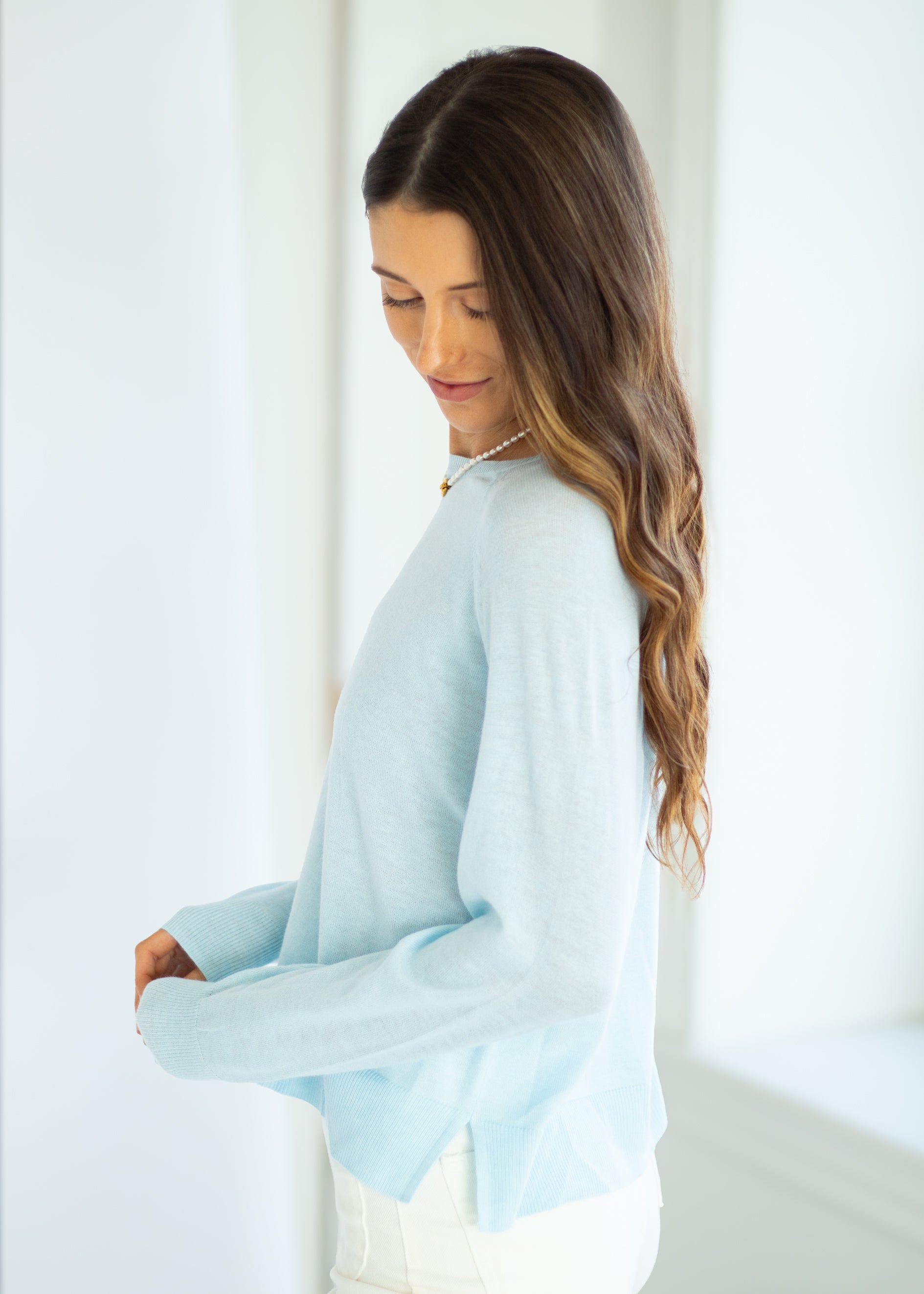 Woman wearing a light blue blouse with a white background
