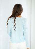 Woman wearing a light blue sweater against a white background