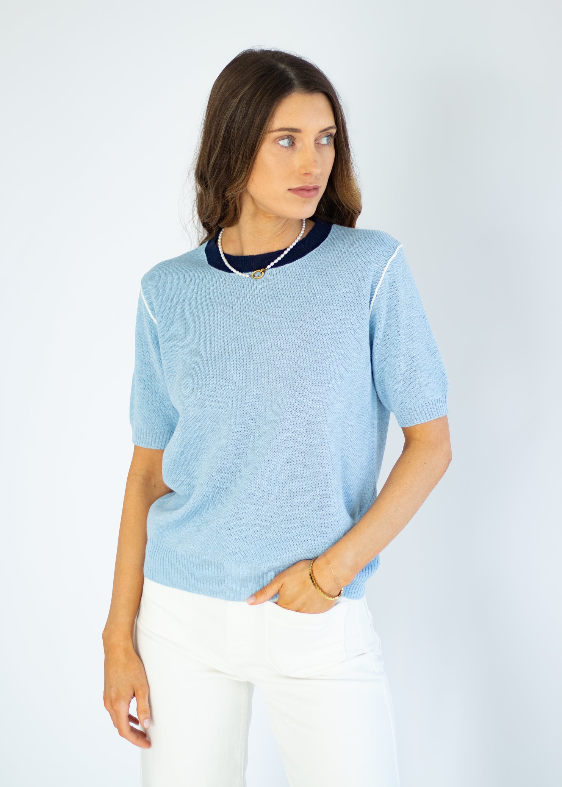 Woman wearing a light blue sweater with a white background