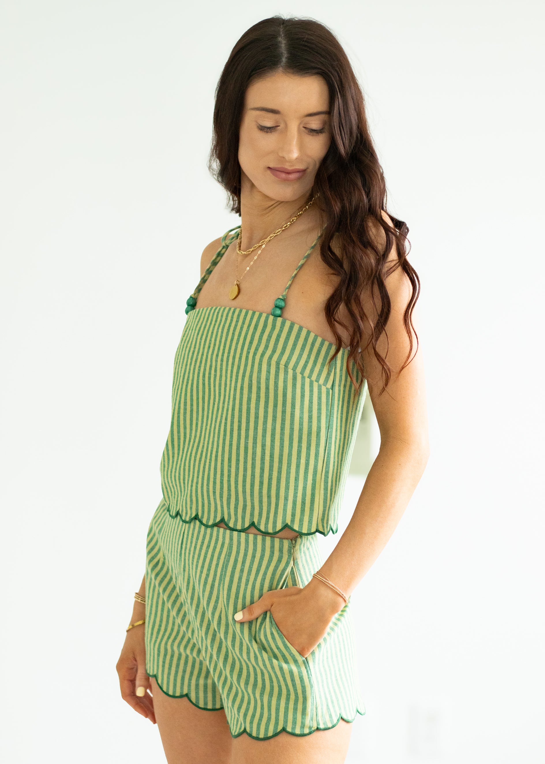 Woman wearing a green striped set on a white background