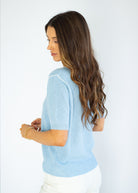 Woman wearing a light blue sweater against a white background