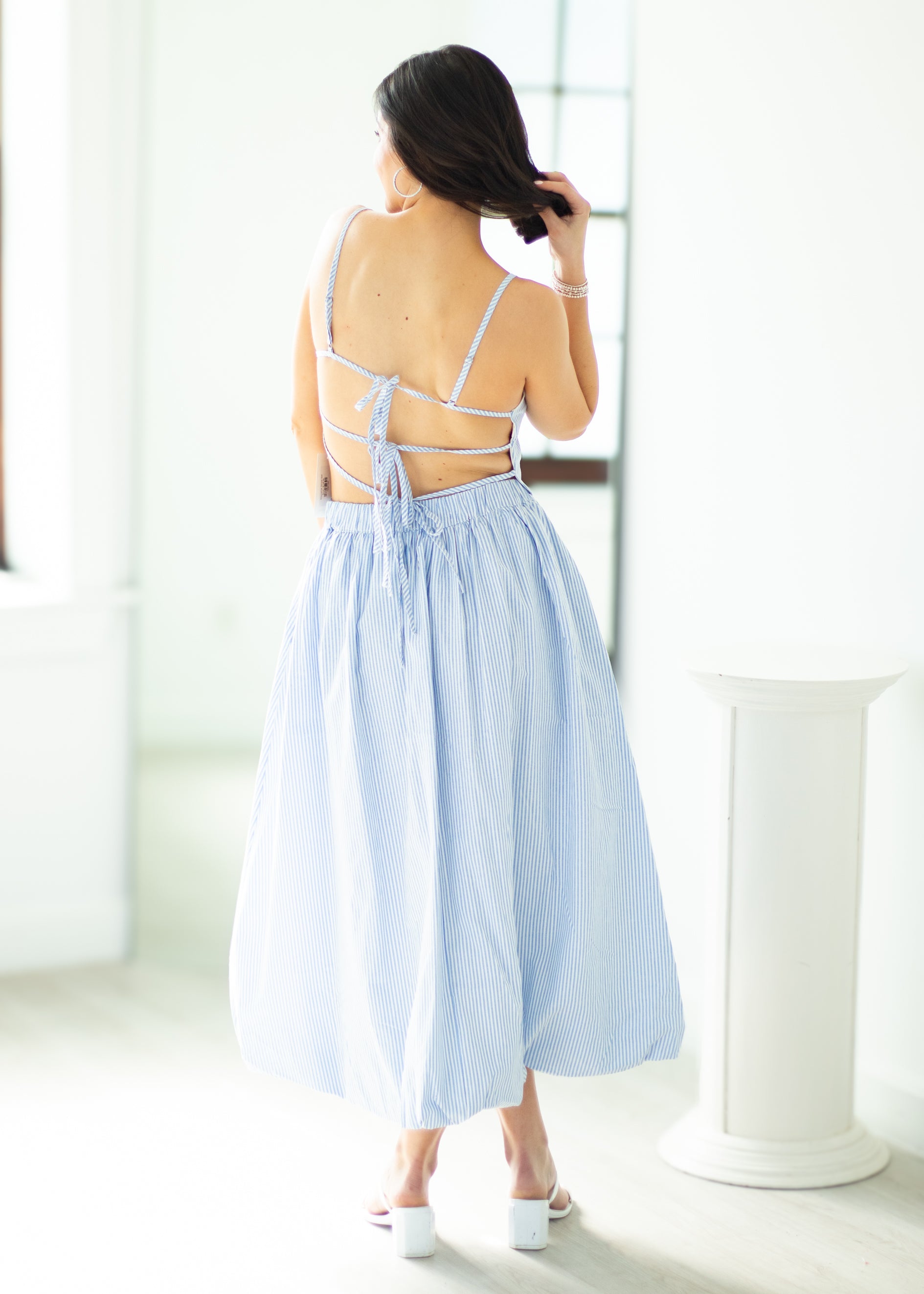 Woman wearing a light blue dress with a white background
