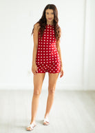Woman wearing a red polka dot set on a white background
