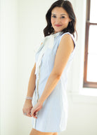 Woman wearing a light blue striped shirt with a white bow tie against a white background