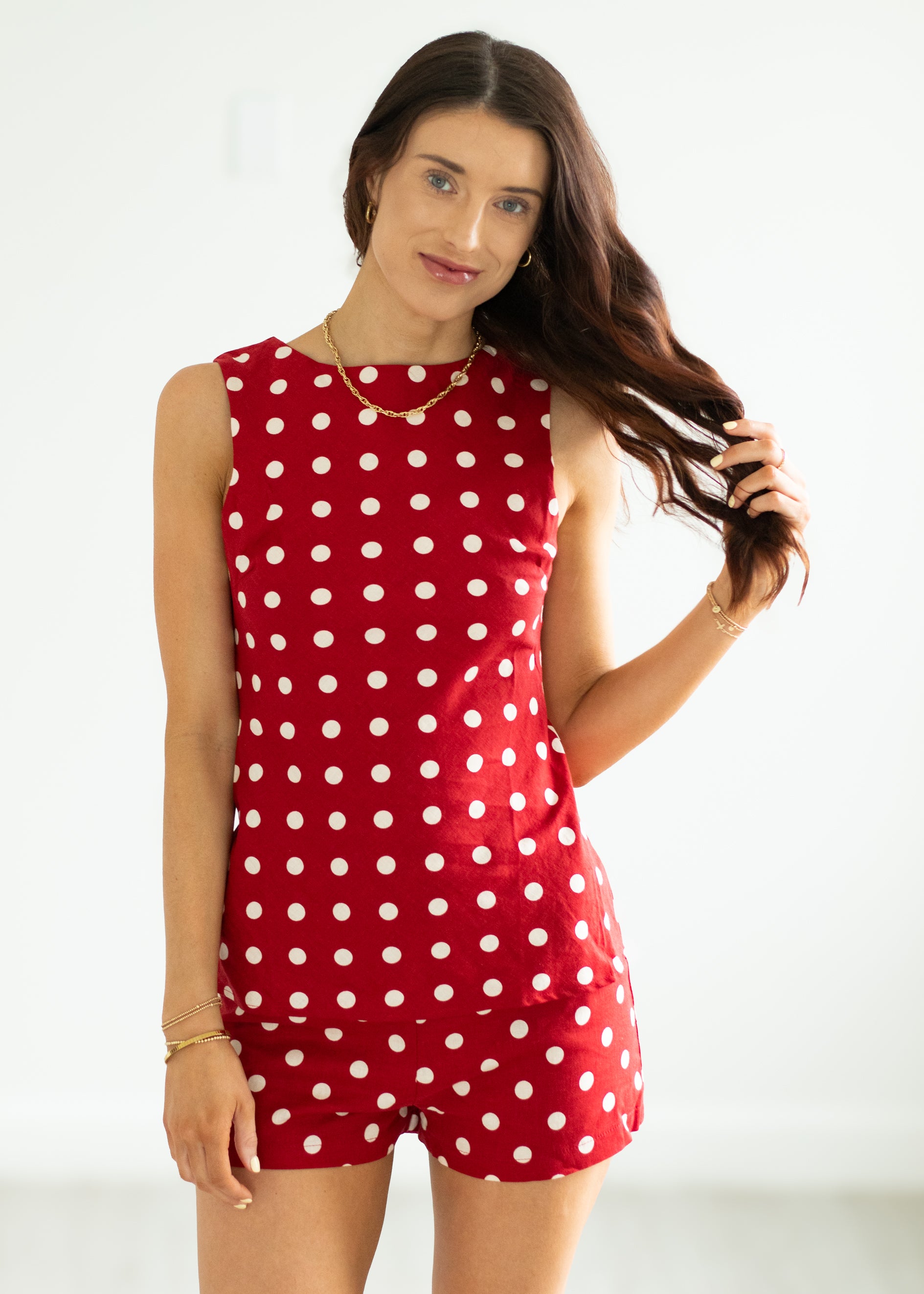 Woman wearing a red polka dot set on a white background