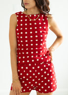 Woman wearing a red polka dot set on a white background