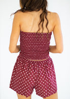 Woman wearing a polka dot romper on a plain background