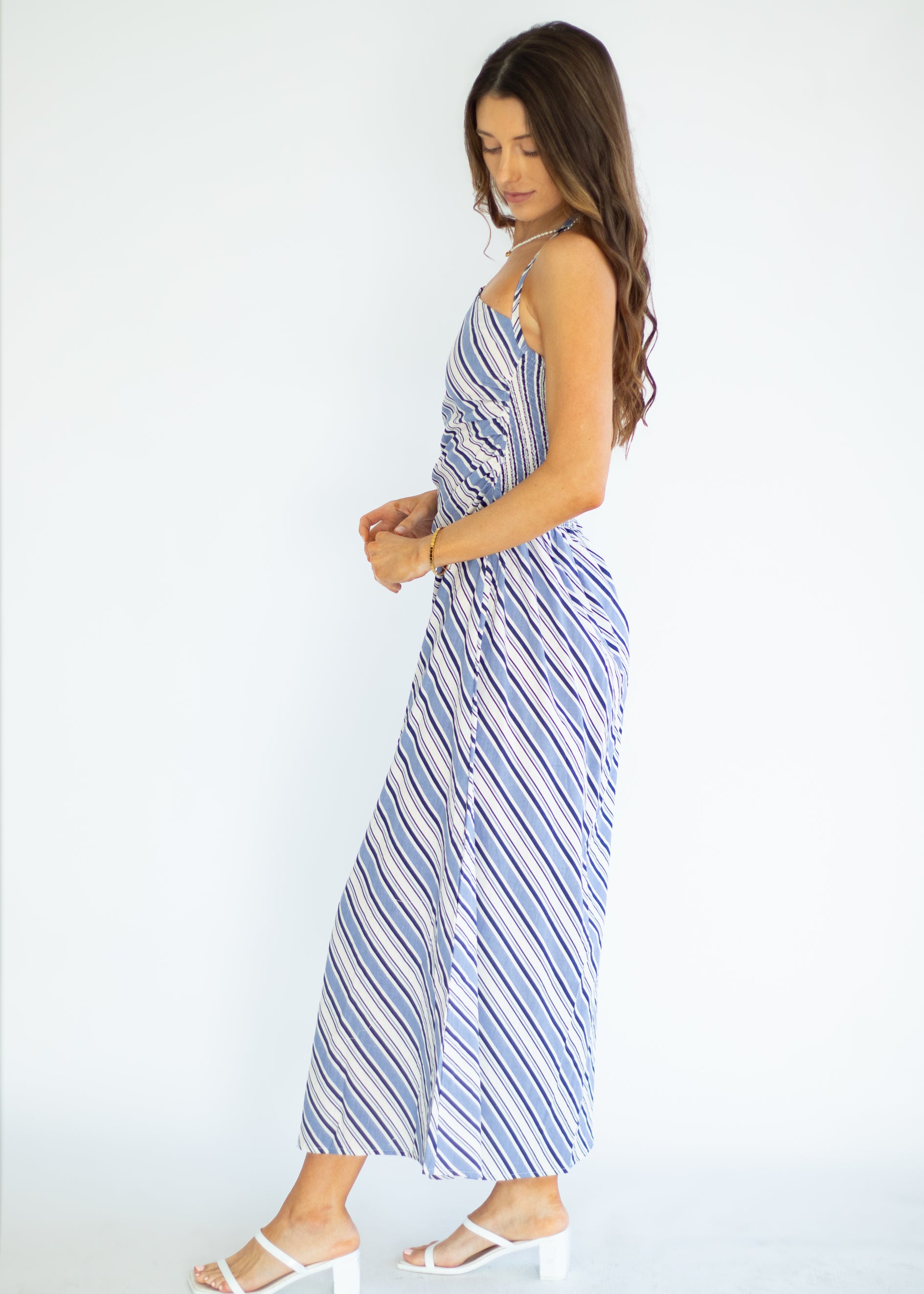 Woman wearing a blue and white striped dress on a white background