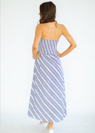 Woman wearing a blue and white striped dress against a white background