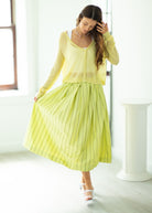Woman wearing a yellow outfit in a bright room