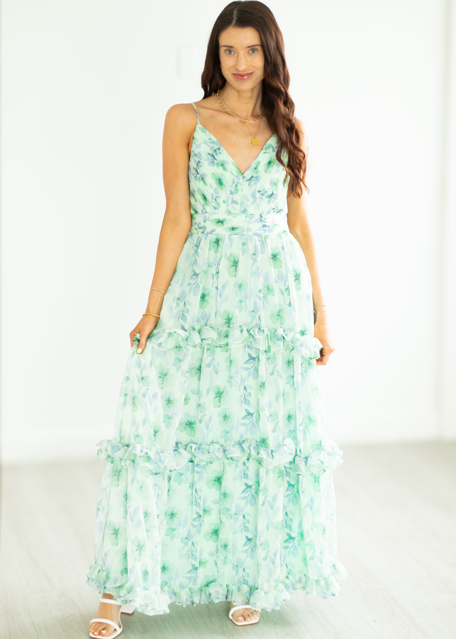 Woman wearing a green floral dress on a white background