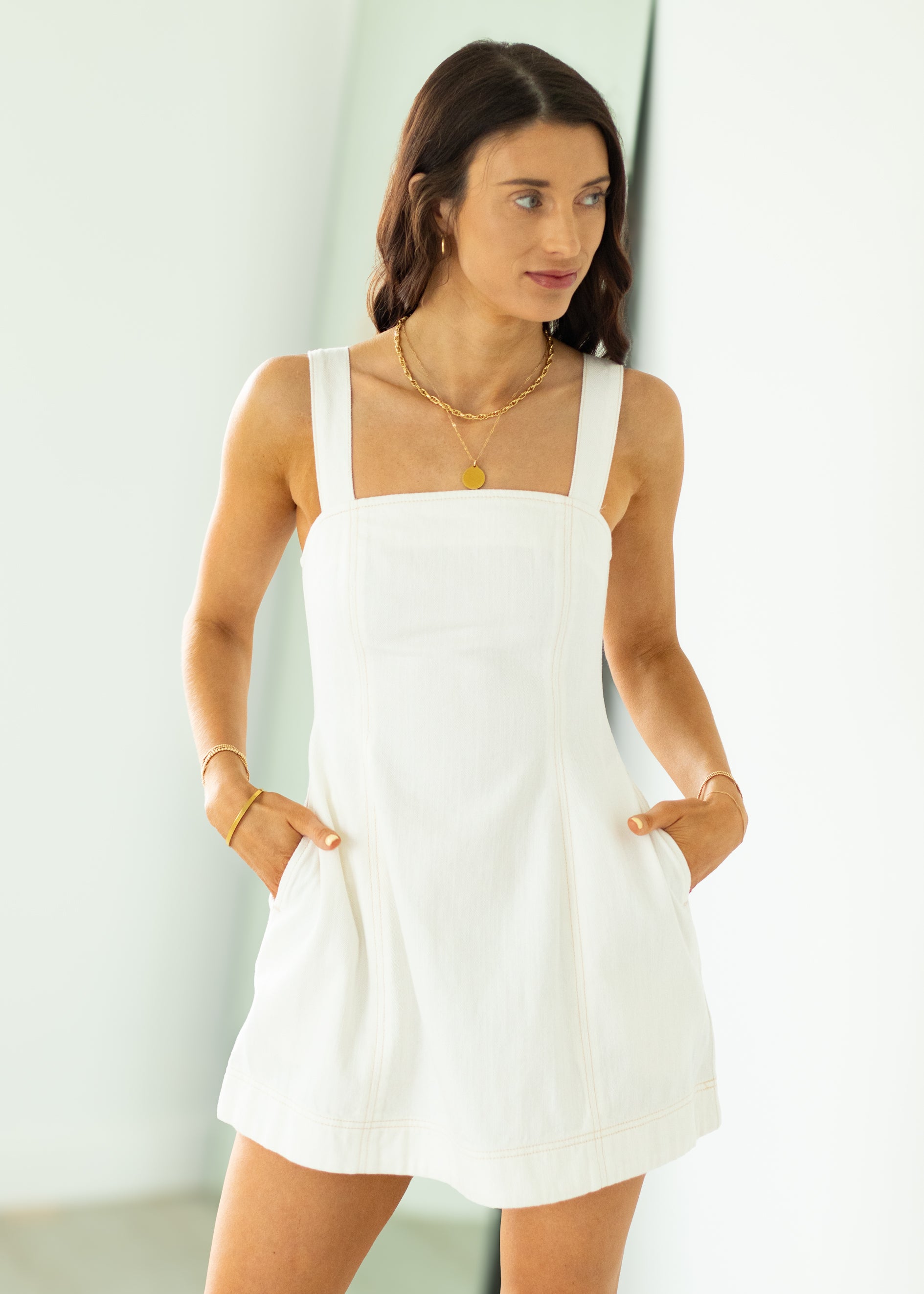 Woman wearing a white dress with a plain background