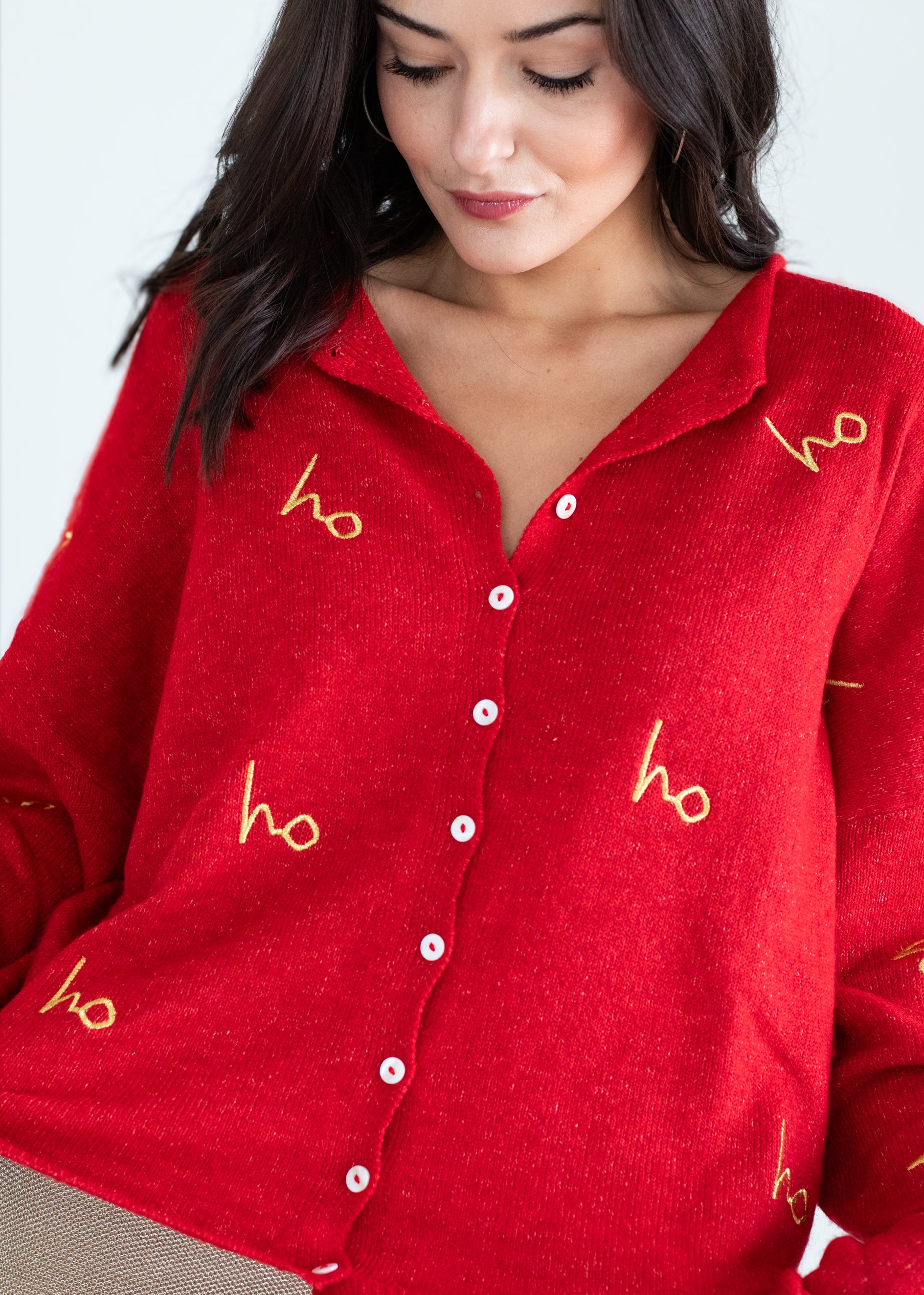 Red shirt with gold 'ho ho ho' text worn by a person, on a plain background