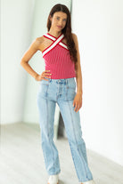 Woman wearing a red and white striped top and blue jeans against a white background