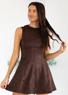 Woman wearing a brown dress against a white background
