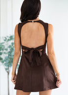 Brown dress with open back and bow detail on a white background