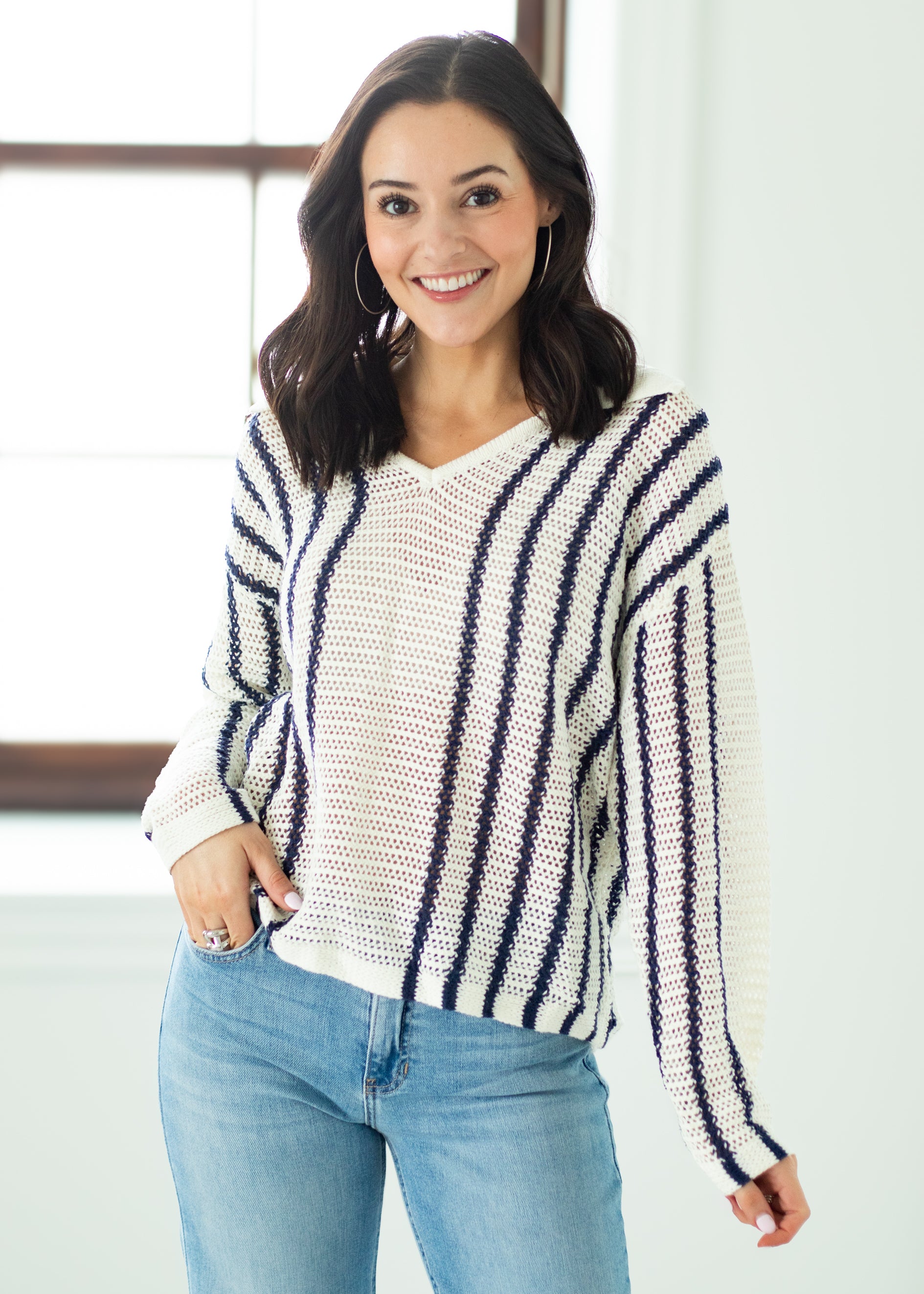 Woman wearing a striped sweater and jeans indoors