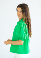 Woman wearing a green blouse against a white background