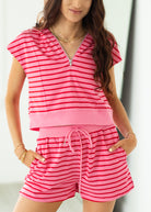 Woman wearing a pink and red striped outfit with a white background